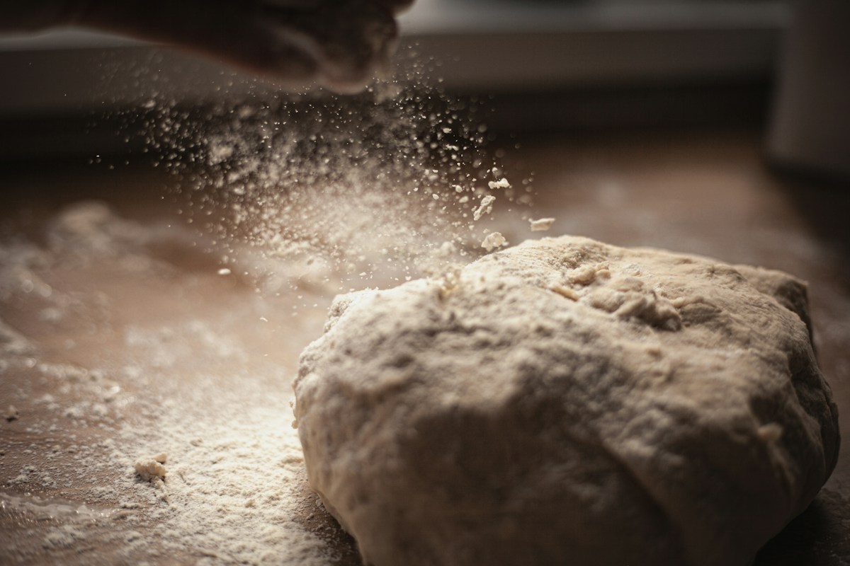 Hands dusting flour in the kitchen